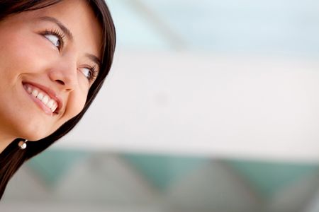 Thoughtful business woman looking up and smiling