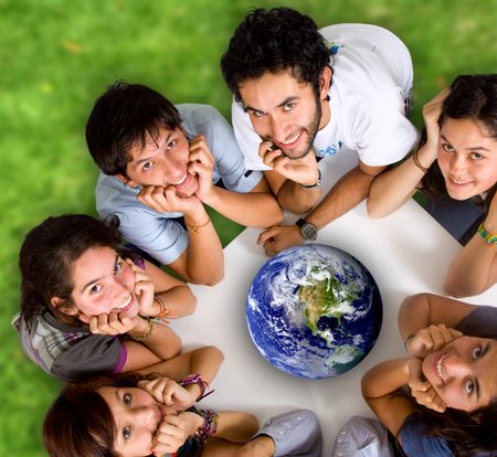group of young ecologists smiling at the camera with a globe in the middle of them