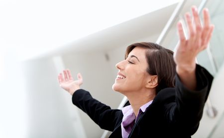 Successful business woman with arms opened at the office