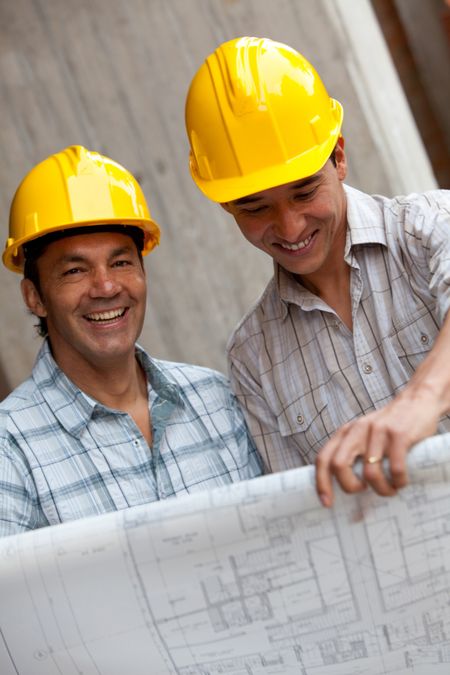 Engineers smiling and holding a model in a construction