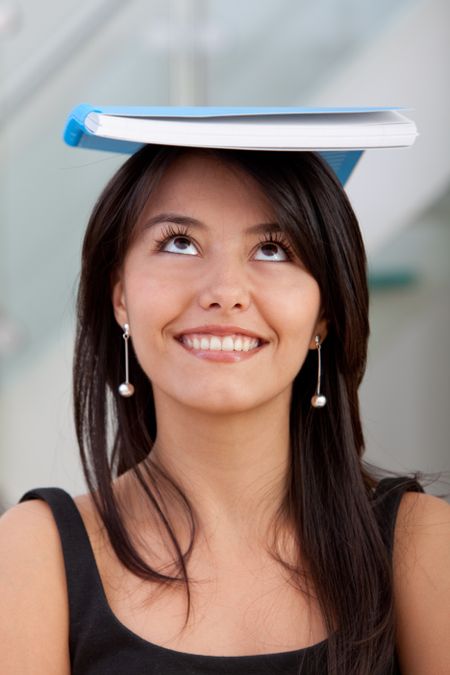 Thoughtful business woman with a notebook on her head