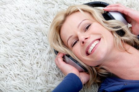 Woman listening to music lying on the floor at home