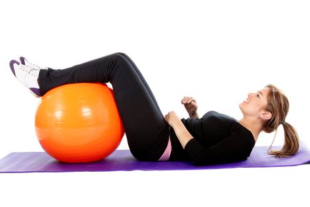 Woman exercising with a pilates ball - isolated over a white background