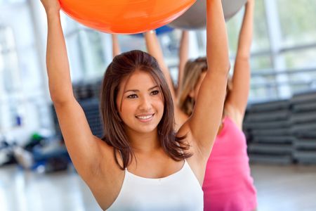 Woman at the gym exercising with a pilates ball