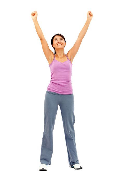 Happy fitness woman in tracksuit with arms up - isolated over white