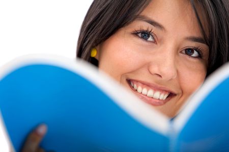 Woman with a notebook in front of her face and smiling