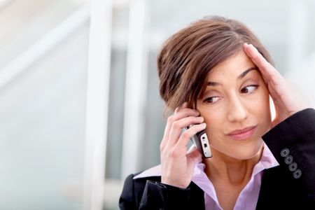 Worried business woman talking on the phone in her office