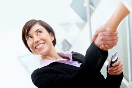 Business woman smiling and making a deal in her office