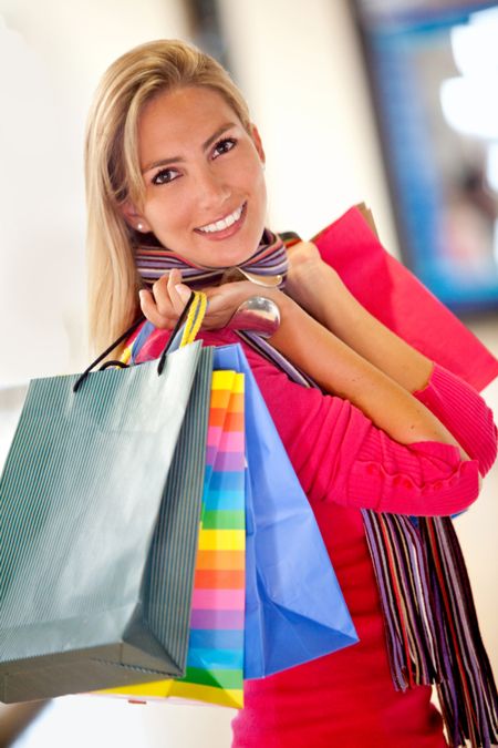 happy woman smiling with shopping bags in a mall