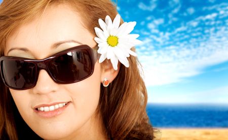 Fashion summer portrait of a beautiful girl by the beach wearing sunglasses