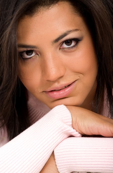 fashion woman portrait close up where she is smiling with her hands underneath her face
