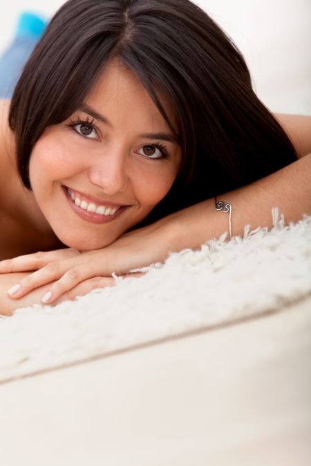 Beautiful woman lying on the floor indoors and smiling