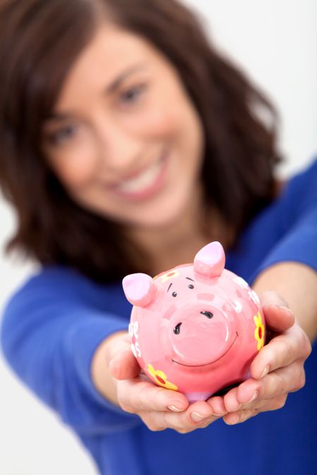 Woman displaying a piggy bank thinking about the house funds