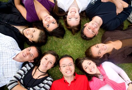 group of happy friends smiling with heads together on the floor