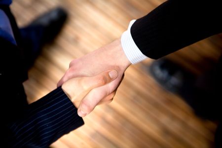 business handshake to seal the deal in an office
