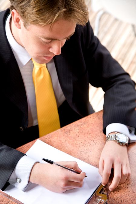 business man doing his books on a table - isolated over a white background