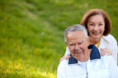 Happy retired couple outdoors smiling and enjoying nature