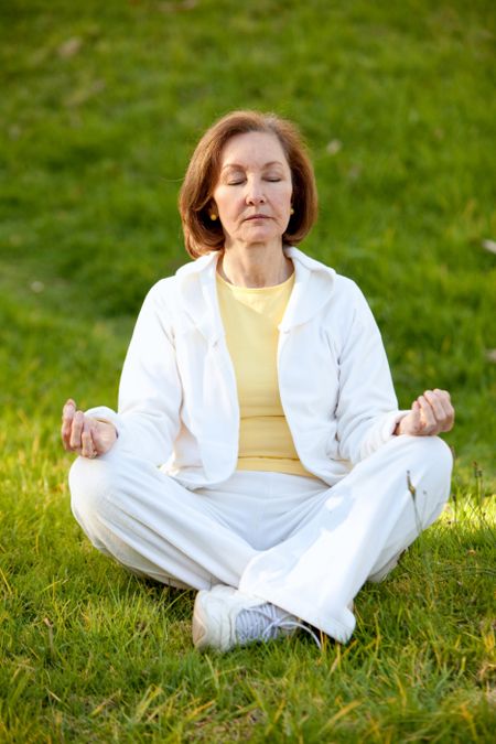 Woman with her eyes closed practicing yoga outdoors