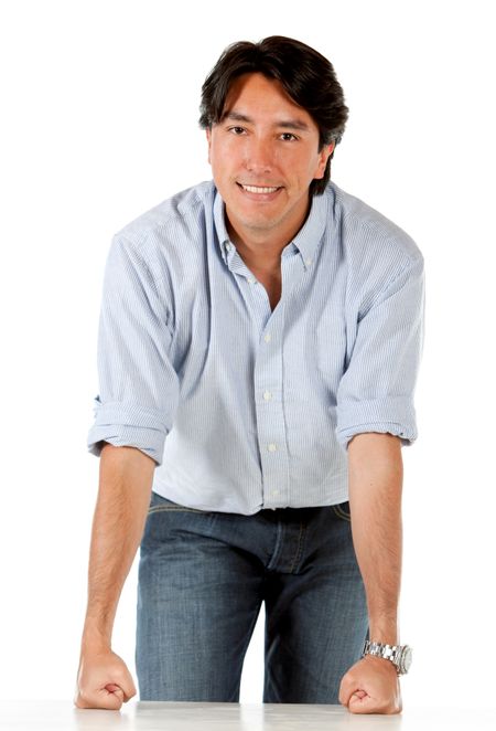 Casual man leaning on a table isolated over a white background