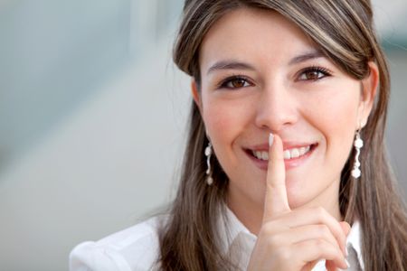 Business woman making a keep it quiet gesture with her hand