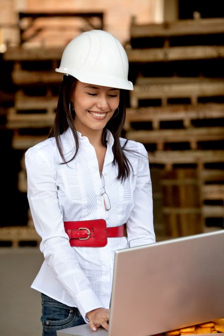 Female architect with a laptop at a construction site