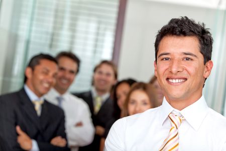 Business man at the office with a group behind