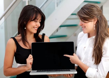 Young business women holding a laptop at the office