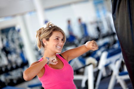 Beautiful woman at the gym boxing and smiling