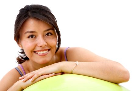 Woman leaning on a pilates ball isolated over a white background