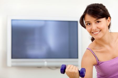 Woman exercising at home in front of the tv