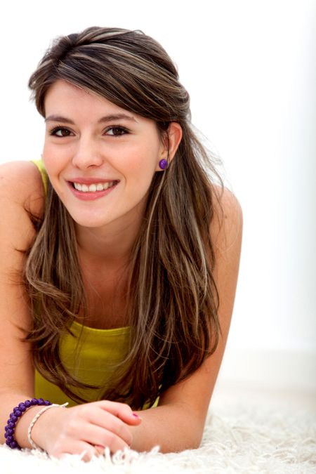 Beautiful young woman lying on the floor and smiling