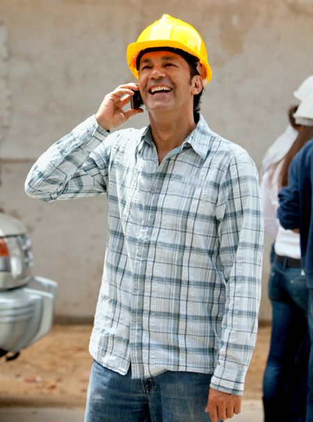 Male construction worker talking on the phone and smiling