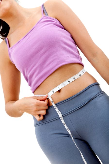 Fit woman measuring her waist - weight loss concepts