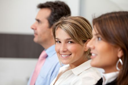 Happy business team smiling at the office looking to the side