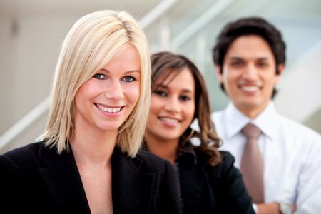 Business woman smiling with her team behind her