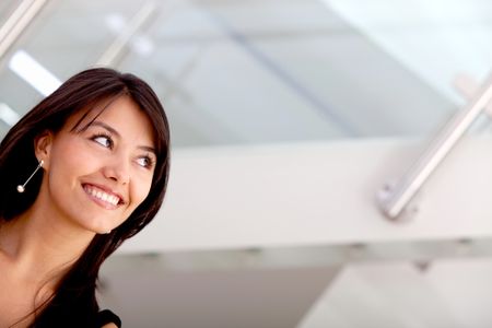 Friendly business woman smiling and looking up in her office