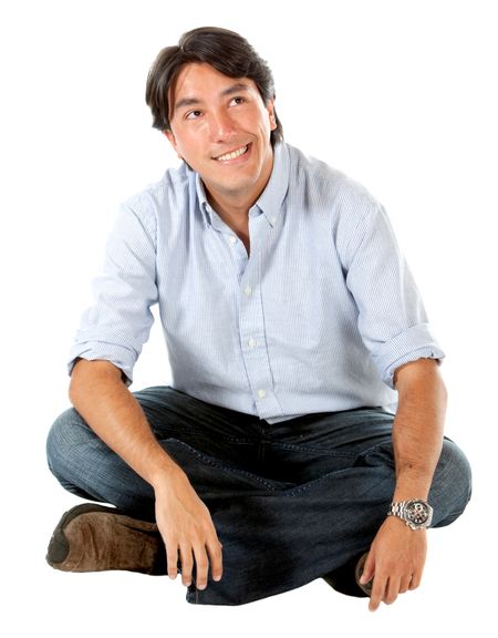 casual man thinking and sitting on the floor isolated over a white background
