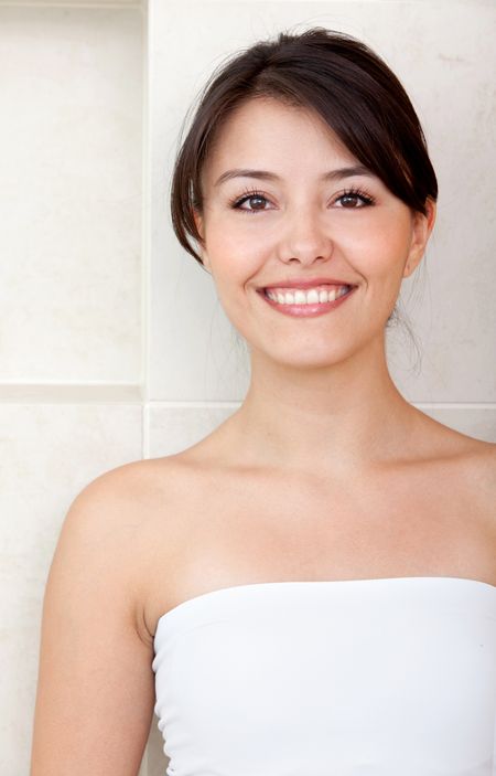Beauty portrait of a pensive female smiling at a bathroom