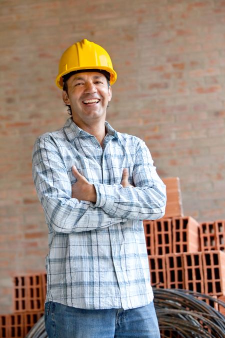 Elegant engineer smiling with arms crossedl in a construction