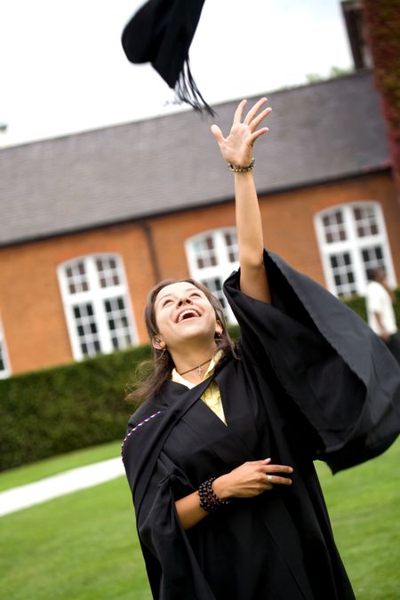 portrait of a female graduating at university throwing her hat