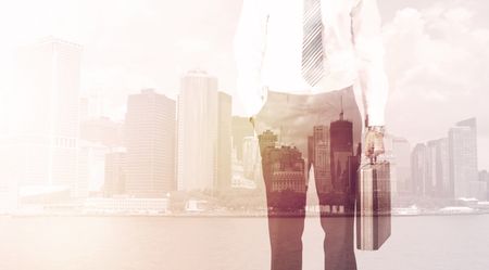 Businessman standing at cityscape background with warm light