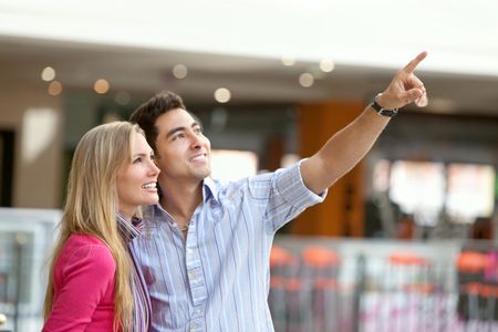 Happy couple at a shopping center smiling and looking something
