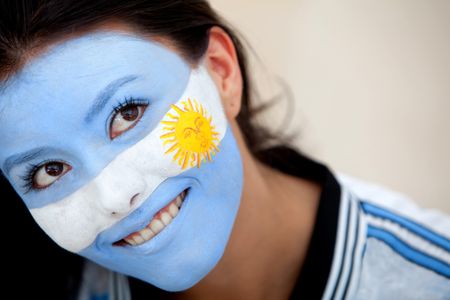 Portrait of a woman with the argentinian flag painted on her face