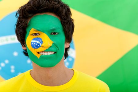 Portrait of a man with the brazilian flag painted on his face