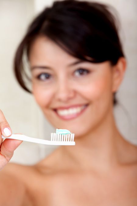 Woman holding a toothbrush in front of her face