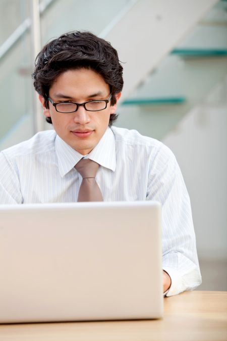 business man looking happy on a laptop in his office