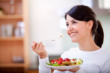 casual woman smiling and having fruit for breakfast