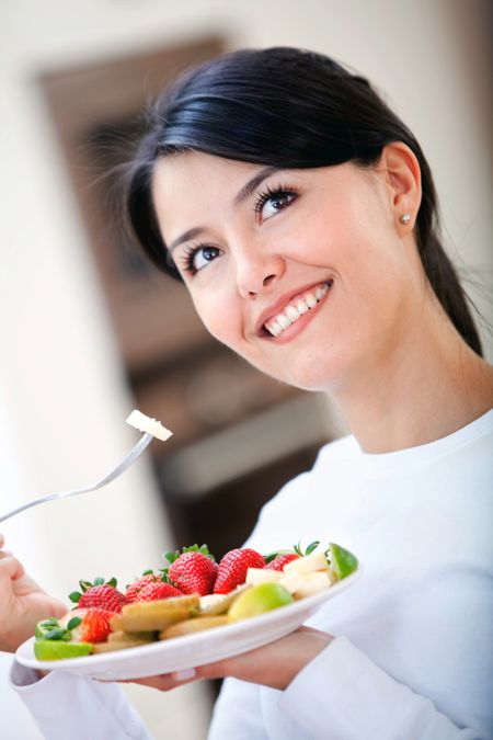 casual woman smiling and having fruit for breakfast