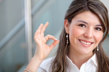 Business woman making an ok sign and smiling