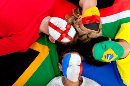 Football fans with painted faces lying on the South African flag - isolated over a white background